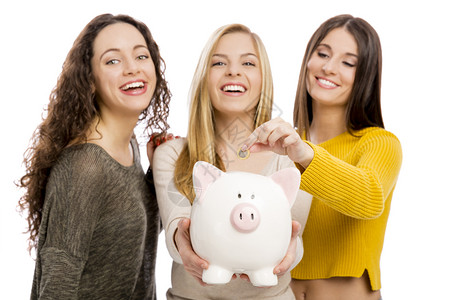 投资愉快多元文化3名少女持有小猪银行的演播室肖像图片