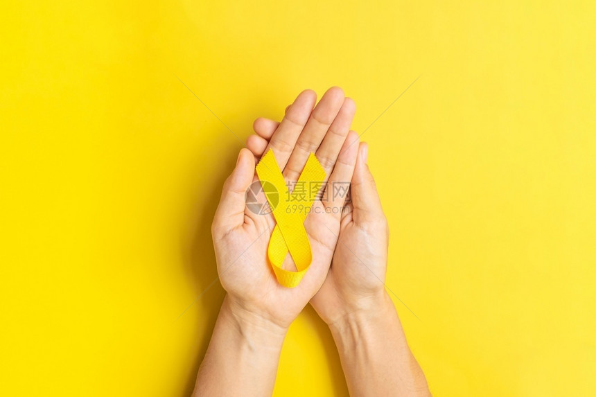 孩子弓9月预防日儿童癌症意识月和世界癌症日概念WorldCancomeday概念以黄色背景持有丝带支生活与疾病的人医生图片