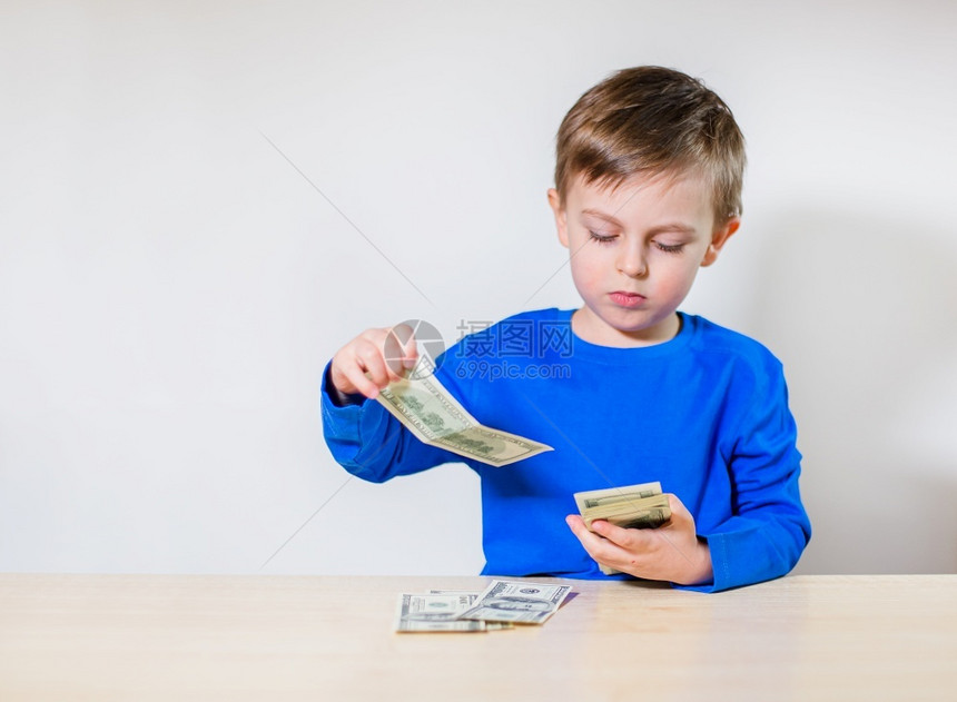 男生白种人青年有钱的快乐孩子小商人一堆美元百钞票在男孩手里有钱的快乐孩子小商人一堆美元百钞票图片