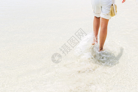 年轻的女人在海滩上散步放松旅行时间腿游脚丫子高清图片素材