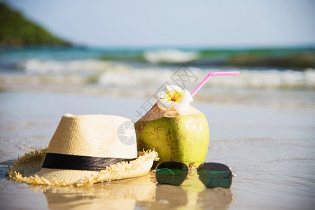 沙滩海边上的草帽墨镜和椰子图片