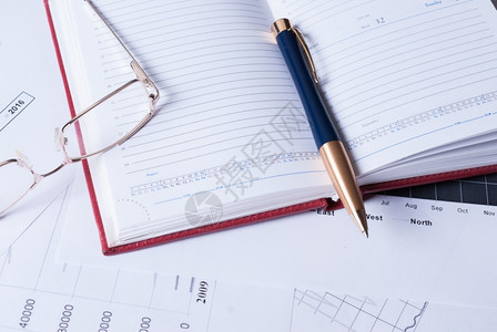 化合物财务图表上面的笔记本和眼镜桩生长基金高清图片素材