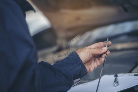 地点汽车机械师在现场服务上检查锅炉机油车械设备关闭手人检查发动机油水平定点底板擦干净检查地板水平然后填满发动机油工程师店铺修理高清图片素材