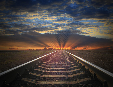 铁轨进入火红的日落查看铁轨进入火红日落的黑暗景观铁路空的地平线图片