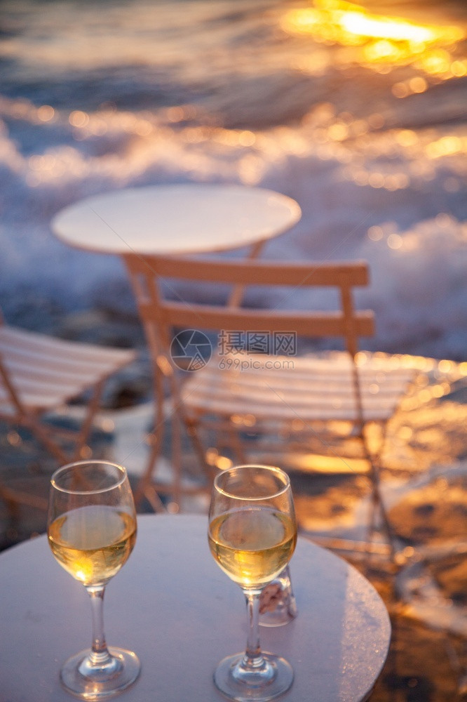 女孩饮料年轻的海边餐桌厅日落夏假期时喝白葡萄酒图片