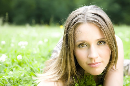 美丽微笑草地上的年轻女肖像公园棕色的高清图片素材