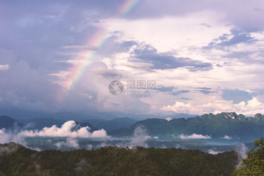 夏天户外彩虹和云背景的风草地图片