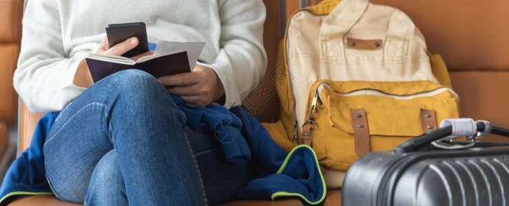 飞机场亚洲女旅行者在机场度假和节日班候机时坐着使用智能手机全景观光的亚洲女旅客正在等待航班票沟通亚洲人高清图片素材