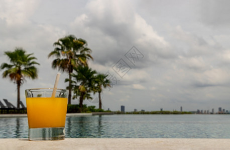保护一种泳池边的放松时刻享受新鲜橙汁休息一下来喝点新鲜橙汁外门游泳池背景休闲活动去郊外游泳池屏幕时尚高清图片素材