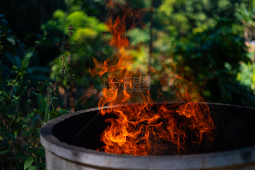 复制壁炉在模糊背景下燃烧火焰的水泥炉燃烧红色热火花上升橙发光的飞行颗粒图片