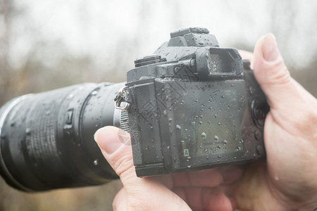 在职的安全秋天一个在雨中拿着摄像头的影师背景图片