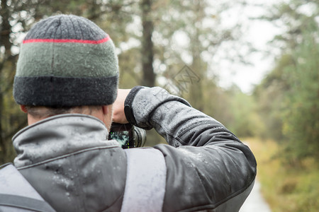 雨衣季节外套一个在雨中拿着摄像头的影师背景图片