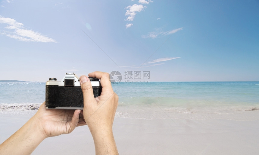 保持拍摄影机的男子准备在海滨上拍照片有蓝天空背景男工作图片