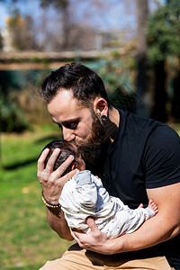 为人父母快乐的年轻亲拥抱和吻他可爱的新生婴儿脸保护图片