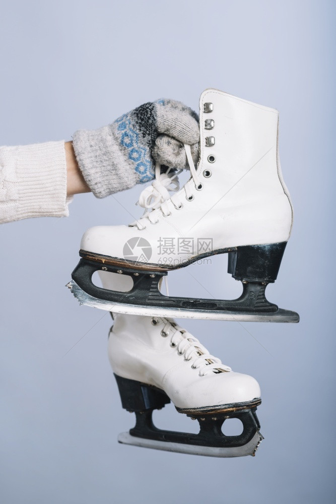 爱溜冰场抓住拿着白色冰鞋手的女人分辨率和高质量的美丽照片女人拿着白色冰鞋的手高质量和分辨率的美丽照片概念图片