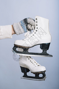 冰手高清素材爱溜冰场抓住拿着白色冰鞋手的女人分辨率和高质量的美丽照片女人拿着白色冰鞋的手高质量和分辨率的美丽照片概念背景