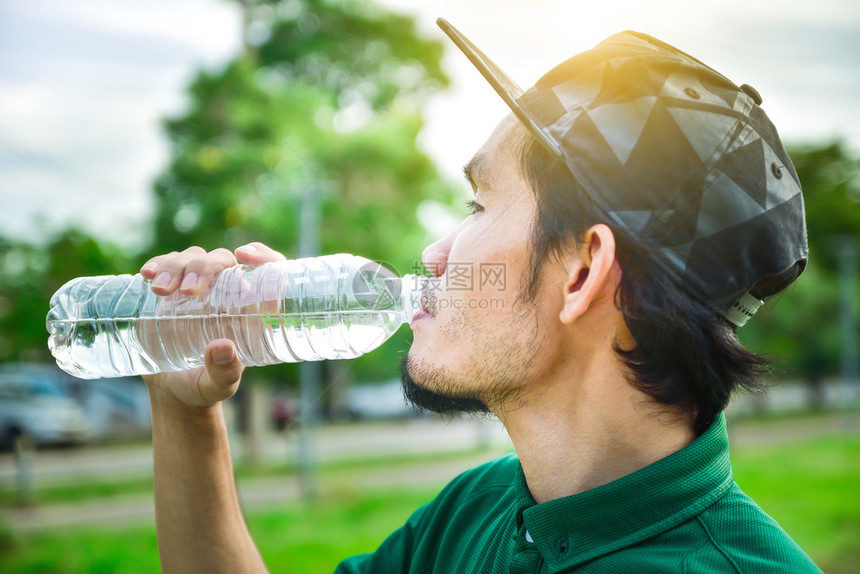 年轻的饮食男子在慢跑冲水和饮料之后可以用雨水和食物图片