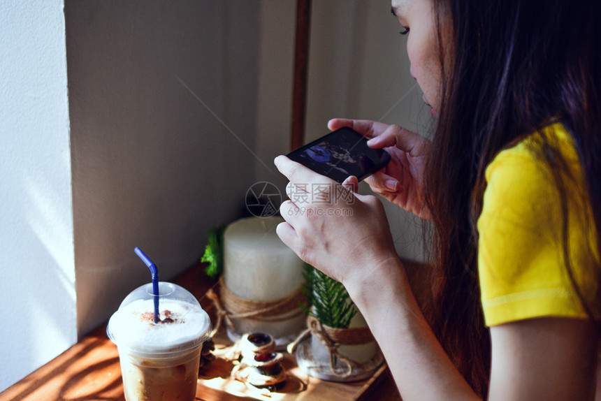 使用智能电话的人在木板上拍摄咖啡的照片潮人社会空白图片