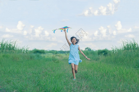 玩亚洲女孩带着风筝跑来去夏天在草地上欢乐的亚裔女孩随意子天空高清图片素材