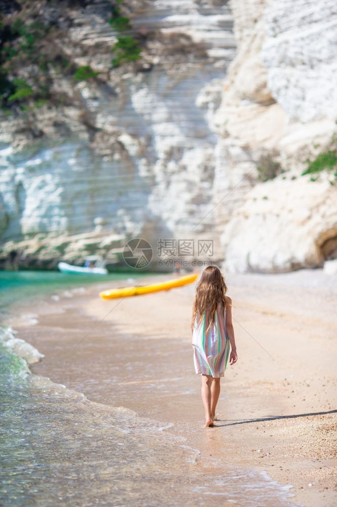 海滩上女孩的背影夏假时在海滩上可爱的小姑娘海滨婴儿绿松石图片