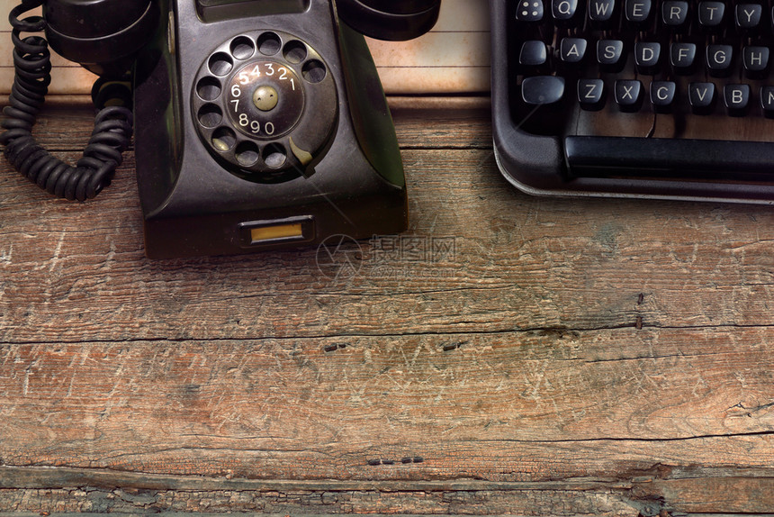 打印木制桌背景的旧黑色电话和打字机艺术办公室图片