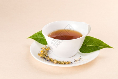 饮料白色的陶瓷杯中红茶配绿叶装饰色图片