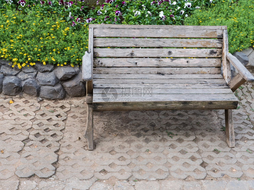 夏天在公共园花棚附近的砖地板上摆木凳子松弛院图片