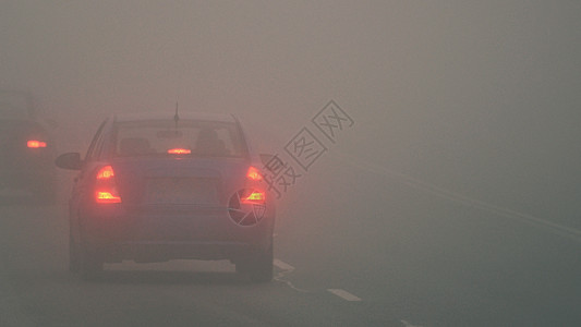 灯迎面而来冬季天气恶劣公路上的轻型车辆在雾中危险机动车交通情况也十分危险晚上坏的高清图片素材