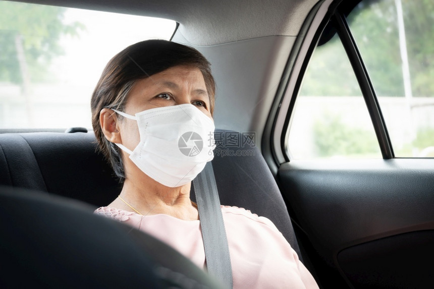 汽车里戴口罩预防的女乘客图片