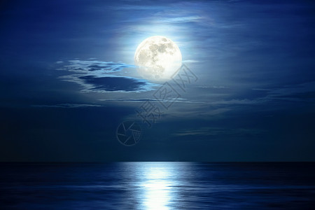 浪漫的午夜时分超满月和蓝天的色空中超级满月和云雾在海洋地平线上方月光反映水面和波浪夜晚海景中美丽的自然风景观作为背黑暗颜色发光的高清图片素材