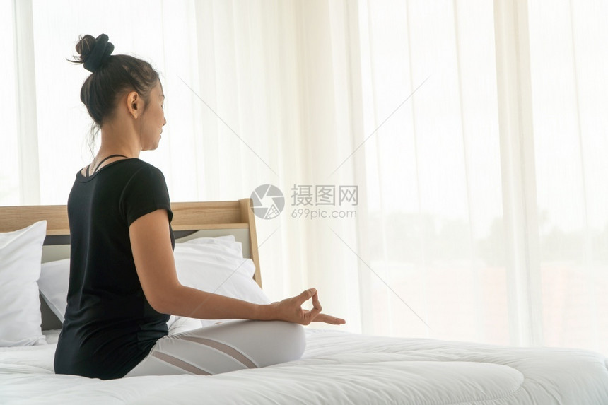 美丽训练健康做瑜伽的中年妇女早上在卧室用瑜伽进行默思时容易装扮成瑜伽上午运动和放松的概念图片