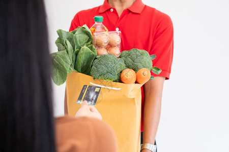 一种商业来自超市的亚洲送货员身戴面罩持有一袋新鲜食品蔬菜和水果供家里顾客使用特快杂货服务和新生活方式概念服务与新生活方式快乐的快速地高清图片素材