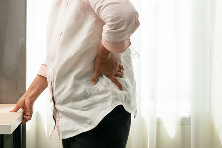老年妇女在家背痛健康问题概念接触沙发不良图片