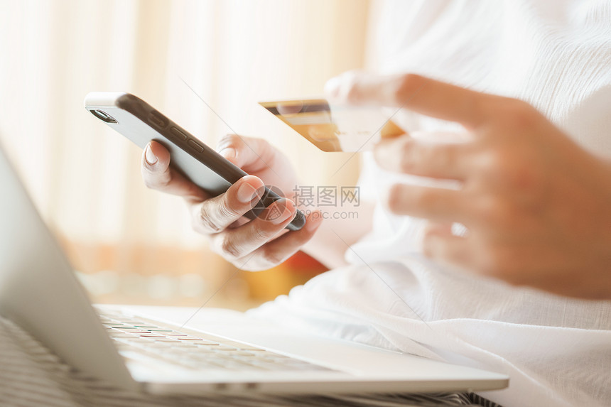 在线的近身妇女正在网上与信用卡使智能电话和进行在线交易的妇女一起购买个信用卡这些妇女正在利用智能手机进行在线交易人们银行业图片