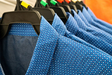 男布衣柜内架上一排蓝色男子衬衫零售商棉布蓝色的图片