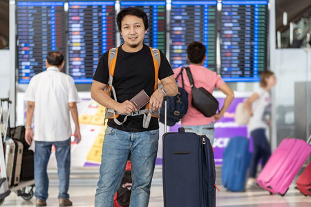 到达休息室人们在现代机场飞行信息屏幕上登机旅行和具有技术概念的运输等现代机场旅行和运输时有护照的亚洲旅行者在飞板上站立着检查行李木板高清图片素材