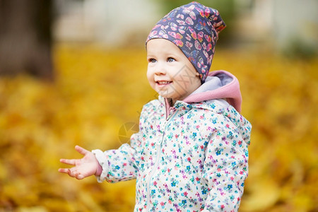 秋天在公园玩落叶的小女孩图片