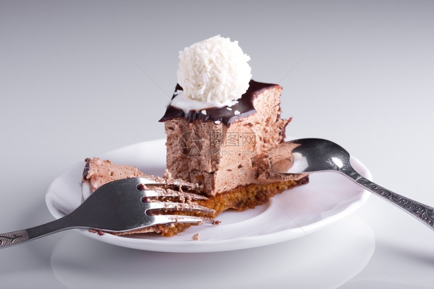 含糖的可口白盘上美味巧克力蛋糕有叉子和勺庆祝图片