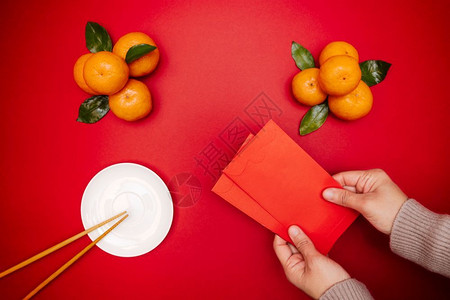 人新年月球菜在餐桌顶上放红包的平面彩色新年传统食物问候礼图片