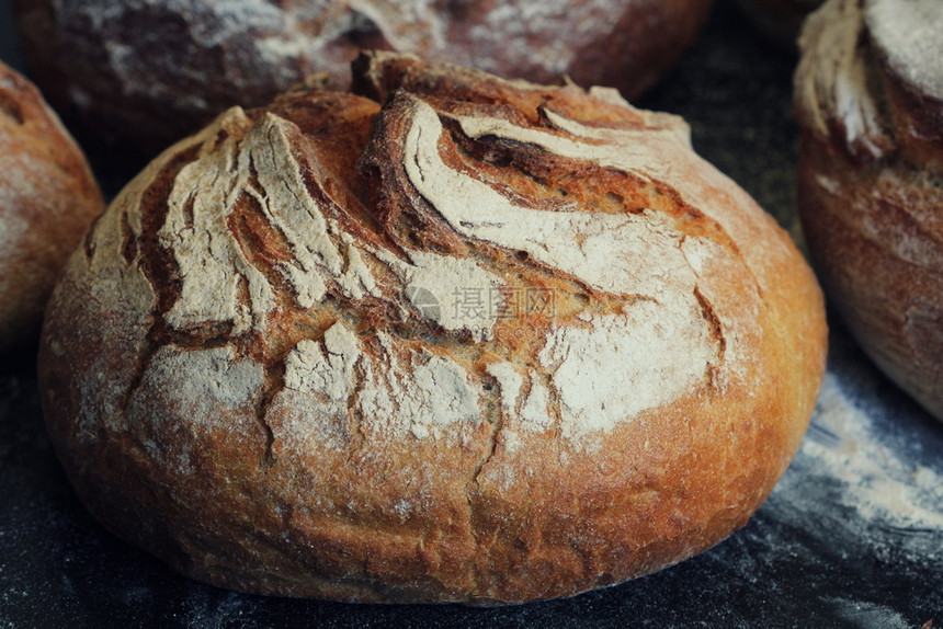 小麦厨房生锈黑暗背景的土制面包新鲜烘烤图片