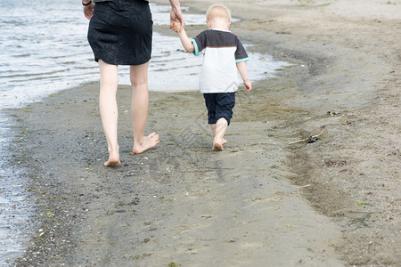 母亲和儿童在沙滩上行走图片