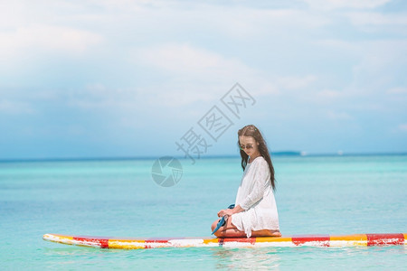坐在桨板上冲浪的女人划桨高清图片素材