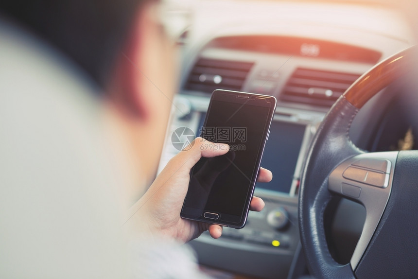 商业一名男子在车里使用电话保持事故图片