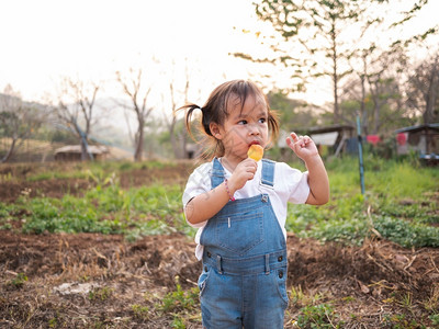 女微笑亚裔小孩在公园散步夏天脸色甜美地吃冰淇淋海滩漂亮的高清图片素材