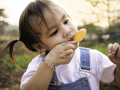 愉快乐的白色亚裔小女孩在公园散步夏天脸色甜美地吃冰淇淋手高清图片素材