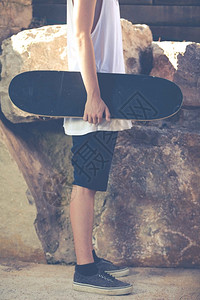 带着太阳眼镜和滑板的年轻男孩决心滑板运动公园图片
