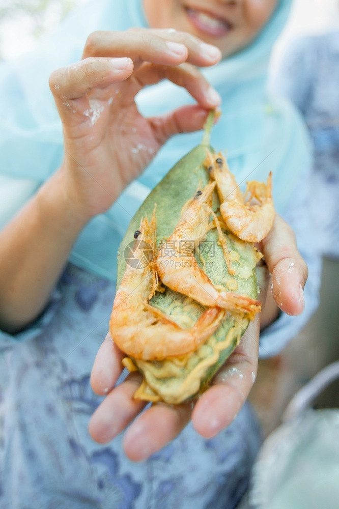 真正的亚洲马来人健康一位亚洲家庭主妇正在用红树叶烹饪真实的炸虾并做红薯条叶亚洲马来风格的海产食品图片