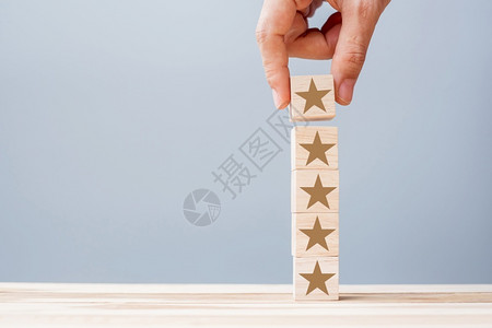 手持带有星号符的木块客户评论反馈级排名和服务理念天受欢迎的商业图片