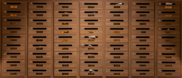 坐垫式储物柜邮资棕色的墙许多用木制成的邮箱放在一楼公寓大以共有式重点收看的邮箱背景