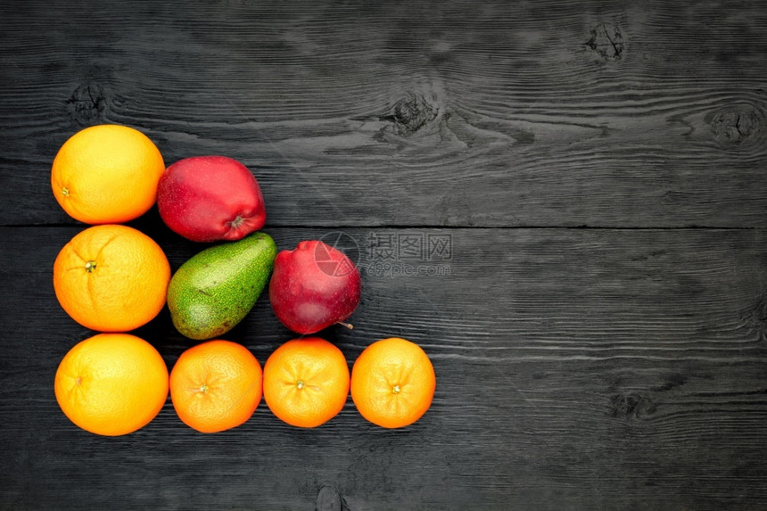 自然橙子橘苹果和鳄梨躺在一个旧黑木板上古色的木质表面生锈风格平地复制空间水果和柑橘复制空间和柑橘制品放在旧黑木桌上买健康图片